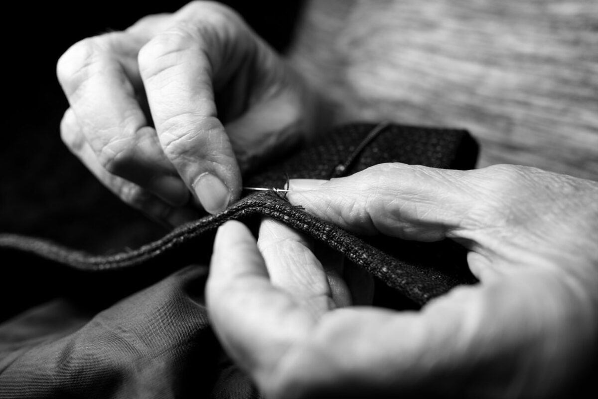 Mãos fazendo costura manual, o começo de quem aprende a costurar sozinho em casa